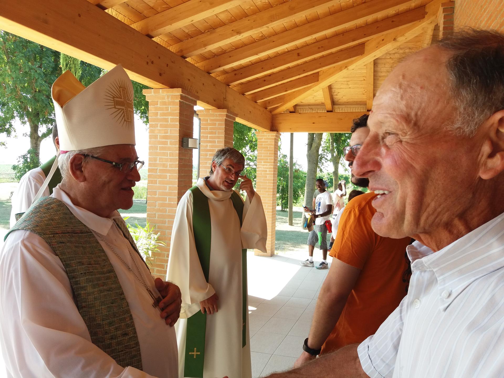 Un vescovo e un altro uomo si salutano sotto un portico