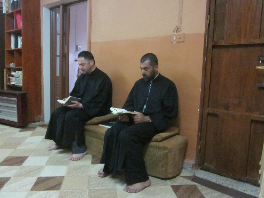 Due monaci seduti in una stanza leggono