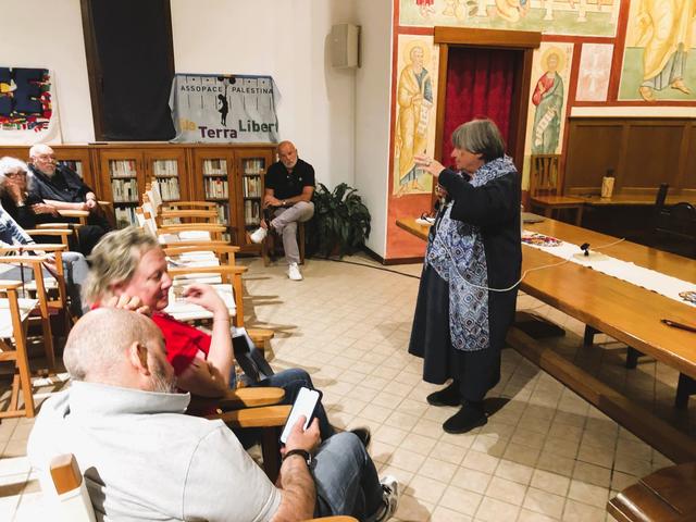 Un incontro con una donna in grembiule davanti ai presenti, in una sala