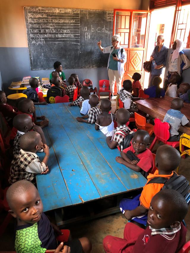 Bambini di una classe attorno a un tavolo blu