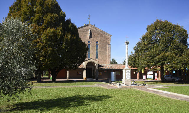 Una chiesa circondata da alberi e prato